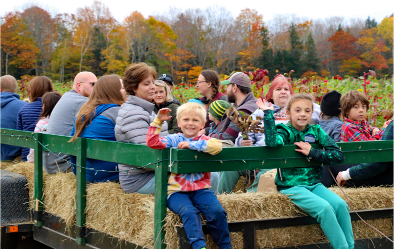 Parents and children on a hayride in autumn.