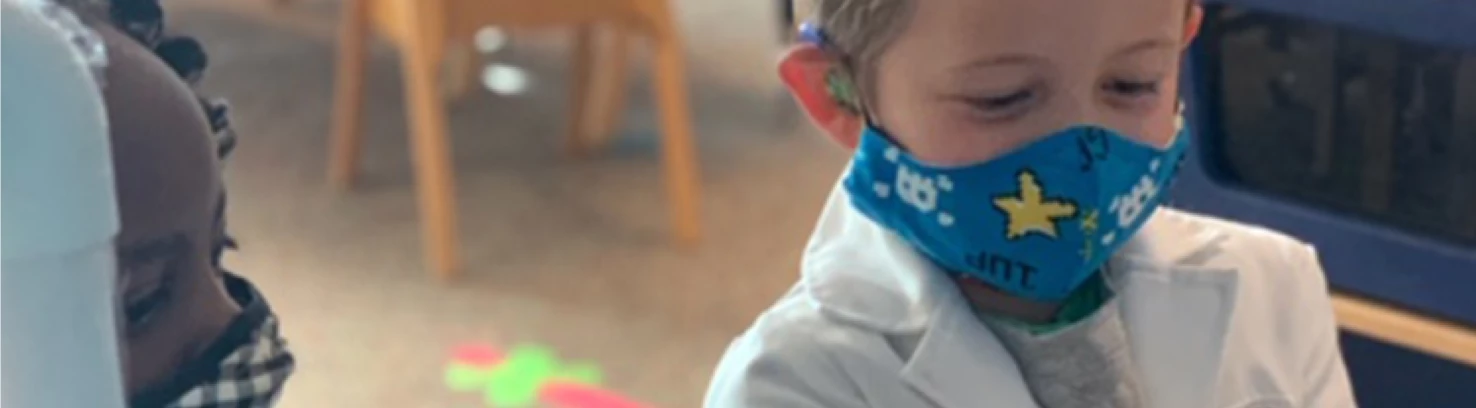 A child in a mask and doctor's coat